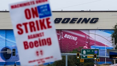 Boeing workers wave picket signs as they strike after union members voted to reject a contract offer, Sunday, Sept. 15, 2024, near the company's factory in Everett, Wash.
