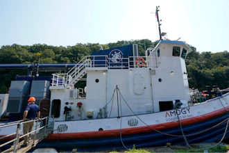 A worker stands near the NH3 Kraken, a tugboat powered by ammonia, on Friday, Sept. 13, 2024, in Kingston, N.Y.