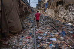 A man walks on a railway track littered with plastic and other waste materials on Earth Day in Mumbai, India, April 22, 2024.
