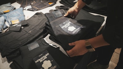 Shop clerk Yuta Akagi displays the jeans at Momotaro Jeans shop in Tokyo, on Sept. 18, 2024.