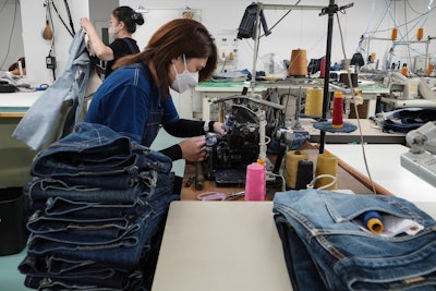 A seamstress works on denim trousers at Momotaro Jeans using a vintage sewing machine in Kojima, Okayama prefecture, western Japan, on Sept. 4, 2024.