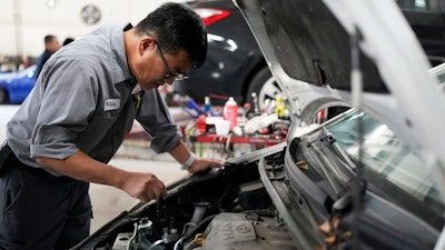 Auto mechanic Willie Chung works on a vehicle at the Express Auto Service Inc., in Chicago, Thursday, Sept. 19, 2024.