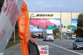 Union machinist Terry Muriekes waves a Halloween-decorated strike sign by Boeing's Everett, Wash., factory on Tuesday, Oct. 22, 2024.