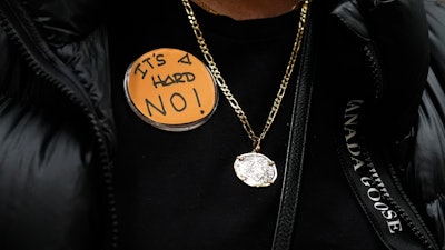 Boeing employee Gina Forbush wears an pin saying 'IT'S A HARD NO!' while listening to the announcement that union members voted to reject a new contract offer from the company, Wednesday, Oct. 23, 2024, at Seattle Union Hall in Seattle.