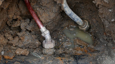 A copper water supply line, left, is shown connected to a water main after being installed for lead pipe, right, July 20, 2018, in Flint, Mich.