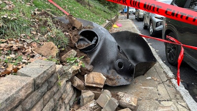 A large metal piece of debris that was flung across a street by a blast at a Louisville, Ky, plant is shown on Wednesday, Nov. 13, 2024. Two workers died in the explosion at the Givaudan Color Sense plant in Louisville.