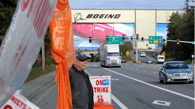 Union machinist Terry Muriekes waves a Halloween-decorated strike sign by Boeing's Everett, Wash., factory on Tuesday, Oct. 22, 2024.