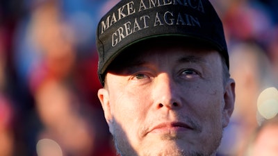 Tesla and SpaceX CEO Elon Musk listens as Republican presidential nominee former President Donald Trump speaks at a campaign event at the Butler Farm Show, Oct. 5, 2024, in Butler, Pa.
