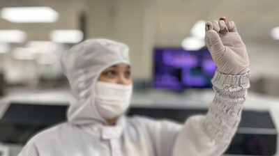 A semiconductor being analyzed by a TI team member.