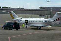 Parked private jets with worker at Zürich Kloten Airport in Switzerland.