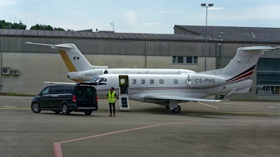 Parked private jets with worker at Zürich Kloten Airport in Switzerland.
