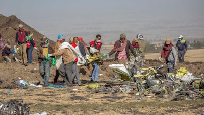Debris is carried at the scene of an Ethiopian Airlines flight crash near Bishoftu, or Debre Zeit, south of Addis Ababa, Ethiopia, on March 11, 2019.