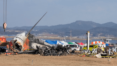 Rescue team members work at the site of a plane fire at Muan International Airport in Muan, South Korea, Monday, Dec. 30, 2024.