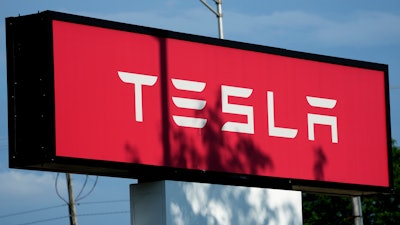 Tesla sign is shown at Tesla dealership in Schaumburg, Ill., Wednesday, July 10, 2024.