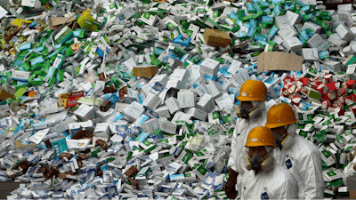 Workers prepare to destroy over 50 tons of confiscated fake medicine during a campaign to mark World Consumer Rights Day in Beijing, Thursday March 15, 2012.