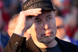 Elon Musk listens as Republican presidential nominee former President Donald Trump speaks at a campaign event at the Butler Farm Show on Oct. 5, 2024, in Butler, Pa.