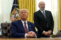 President Trump listens to a question from a reporter as Commerce Secretary nominee Howard Lutnick in the Oval Office, Feb. 13, 2025.