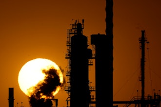 The CHS oil refinery is silhouetted against the setting sun Sept. 28, 2024, in McPherson, Kan.
