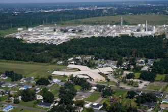 The Fifth Ward Elementary School and residential neighborhoods sit near the Denka Performance Elastomer Plant, back, in Reserve, La., Sept. 23, 2022.