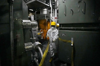 A worker in hazmat suit walks at the area under the Unit 5 reactor pressure vessel, which survived the earthquake-triggered tsunami in 2011, at the Fukushima Daiichi nuclear power plant, run by Tokyo Electric Power Company Holdings (TEPCO), in Futaba town, northeastern Japan, on Monday Feb. 20, 2025.