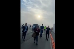 In this image taken from video provided by Justus Rainey, passengers move away from a plane as smoke surrounded the aircraft, in Denver, Thursday, March 13, 2025.