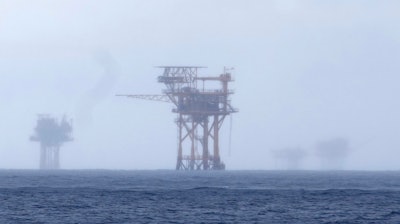 Oil platforms are visible through the haze near the Flower Garden Banks National Marine Sanctuary in the Gulf of Mexico, off the coast of Galveston, Texas, Saturday, Sept. 16, 2023.
