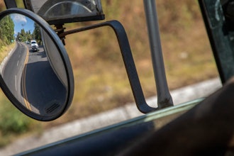 Trucks loaded with avocados are seen reflected on a rear view mirror as they are escorted by the police on their way to the city of Uruapan, in Santa Ana Zirosto, Michoacan state, Mexico, Jan. 26, 2023.