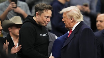 Elon Musk, left, shakes hands with President Donald Trump at the finals for the NCAA wrestling championship, Saturday, March 22, 2025, in Philadelphia.