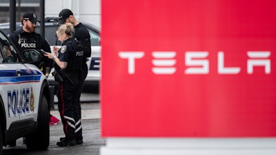 Officers from Ottawa Police Service (OPS) are seen at a Tesla Service and Showroom center after it was damaged with pink spray paint in Ottawa, on Monday, March 31, 2025.