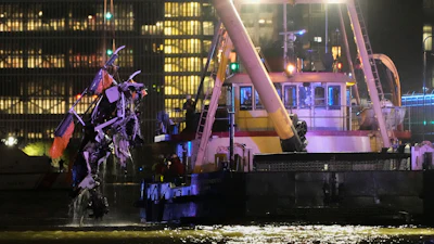 A crane vessel lifts the wreckage of a helicopter that crashed into the Hudson River, Thursday, April 10, 2025, in Jersey City, N.J.