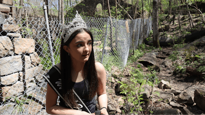 West Virginia Coal Festival teen beauty pageant winner Ava Johnson, 16, collects small pieces of coal left behind at the former Kay Moor coal town and camp in the New River Gorge National Park and Preserve near Fayetteville, W.Va., Thursday, April 17, 2025.