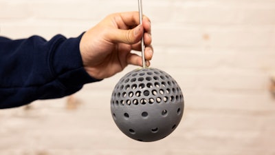 Mechanical Engineering Masters Student, Putu Brahmanda Sudarsana, holds a 3D printed sphere with holes at the Marine Hydrodynamics laboratory on University of Michigan's Central Campus in Ann Arbor, MI on December 17, 2024.