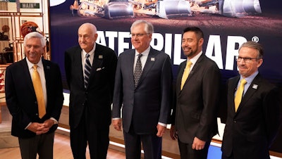 Current, former and incoming Caterpillar CEOs pose for photos on the floor of the New York Stock Exchange, April 15, 2025
