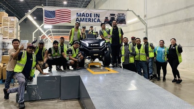 Workers at Kandi's production facility with the first vehicle off the line.
