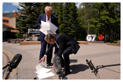 President Donald Trump drops papers as he meets with Britain's Prime Minister Keir Starmer on the sidelines of the G7 Summit, Monday, June 16, 2025, in Kananaskis, Canada.