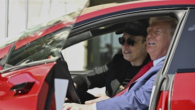 President Donald Trump and Tesla CEO Elon Musk speak to reporters as they sit in a red Model S Tesla vehicle on the South Lawn of the White House, March 11, 2025, in Washington.