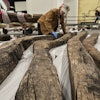 Research assistant Alyssa Carpenter inspects timbers from of a wooden Revolutionary War-era gunboat to prepare for the craft's partial reconstruction at the New York State Museum, Friday, May 30, 2025, in Albany, New York.