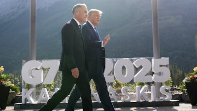 Canada Prime Minister Mark Carney walks with President Donald Trump at the G7 Summit, June 16, 2025, Kananaskis, Alberta, Canada.