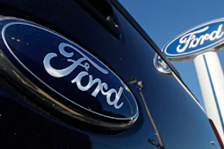A Ford logo is on the tailgate of a pick-up truck and on a Ford dealership sign in Salem, N.H.