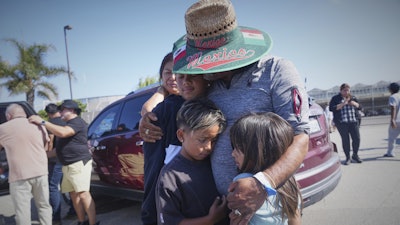 People embrace outside of Glass House Farms, a day after an immigration raid on the facility, on Friday, July 11, 2025, in Camarillo, Calif.