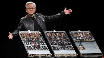 Tech presenter showcasing three open server rack systems on dark stage