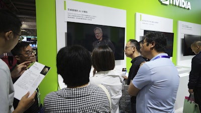 An exhibitor introduces the Nvidia DGX Spark to visitors at the Nvidia exhibition booth during the 3rd China International Supply Chain Expo at the China International Exhibition Center, in Beijing, Thursday, July 17, 2025.