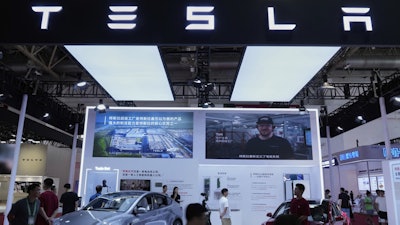 People visit a booth of Tesla during the 3rd China International Supply Chain Expo at the China International Exhibition Center, in Beijing, China, Friday, July 18, 2025.