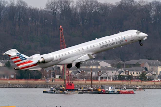 American Eagle regional jet taking off near waterfront with residential area and construction crane