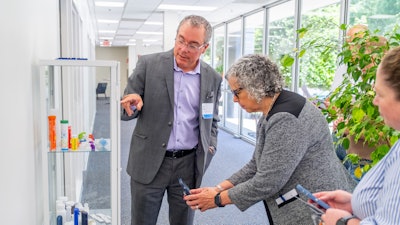 Sanner North America President Ted Mosler shows the company's product portfolio to City of Greensboro Councilmember Tammi Thurm.