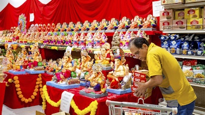 A worker stocks products at New India Bazar, Fremont, Calif., Aug. 6, 2025.