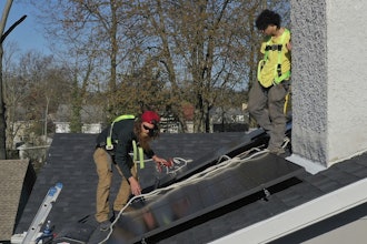 Theodore Tanczuk, left, and Brayan Santos, of solar installer YellowLite, put solar panels on the roof of a home in Lakewood, Ohio, April 17, 2025.
