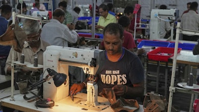 A worker stitches a footwear in a manufacturing unit in Agra, India, Monday, Aug. 25, 2025.