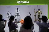 Visitors give commands to a robot at Nvidia's booth during the 3rd China International Supply Chain Expo at the China International Exhibition Center, in Beijing, July 18, 2025.