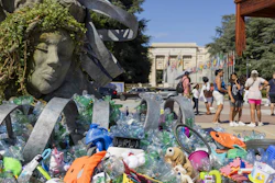 Plastic items are seen next to an artwork by Canadian artist and activist Benjamin Von Wong, titled 'The Thinker's Burden', a 6-meter-tall sculptural remix of Rodin's iconic Thinker, created especially for the Plastics Treaty negotiations, on Place des Nations in front of the European headquarters of the United Nations in Geneva, Switzerland, Monday, Aug. 4, 2025 before the second segment of the fifth session of the Intergovernmental Negotiating Committee on Plastic Pollution (INC-5.2).